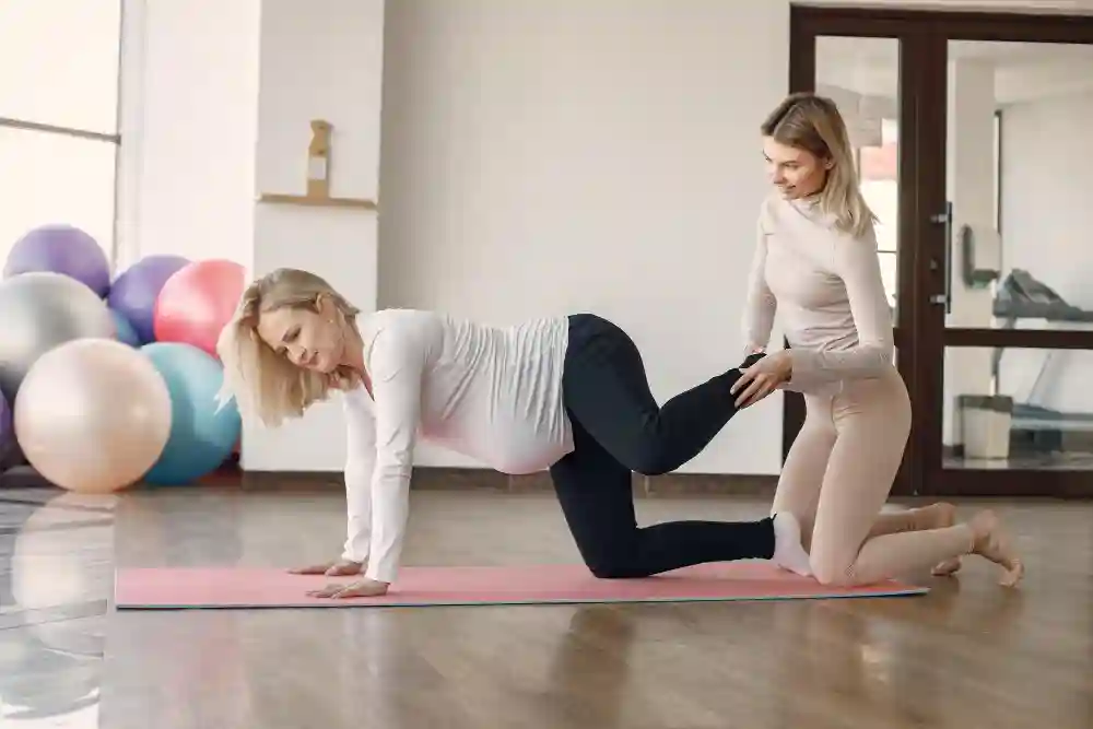 Therapist providing gentle massage to the hip area of a pregnant woman